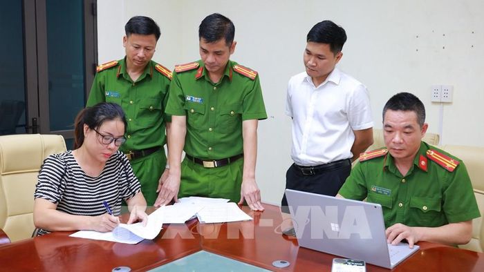 Lực lượng chức năng làm việc với đối tượng Đặng Thị Lý. Ảnh: TTXVN phát