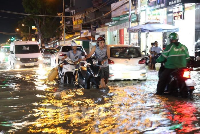 Xe chết máy trên đường Phạm Hữu Lầu, phường Tân Mỹ, ngập sâu do triều cường tối 11/10. Ảnh: Hồng Đạt - TTXVN 