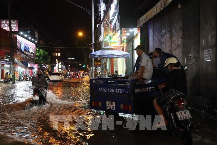 Nhiều người dân lao động TP. Hồ Chí Minh cũng phải ngừng việc mưu sinh vì triều cường. Ảnh: Hồng Đạt - TTXVN 