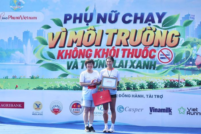 Bà Khúc Thị Hoa Phượng, Giám đốc - Tổng biên tập Nhà xuất bản Việt Nam, trao giải Ba cho vận động viên nữ.