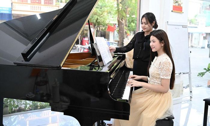  Em Nguyễn Thị Thu Hà (phía trước) luyện tập piano. 