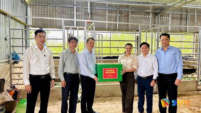 Chủ tịch UBND thành phố Nguyễn Mạnh Hùng (thứ 3 từ trái sang) tặng quà động viên chủ mô hình nuôi hươu lấy nhung tại xã Phước Chánh. Ảnh: VINH ANH