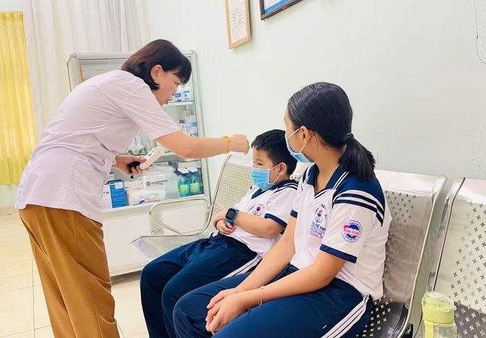  Nhân viên y tế Trường THCS Lương Thế Vinh theo dõi sức khỏe cho học sinh. Ảnh: T.D 