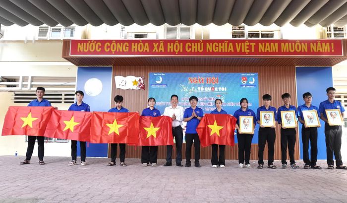Ban tổ chức tặng cờ Tổ quốc và ảnh Bác Hồ cho đoàn viên, thanh niên.