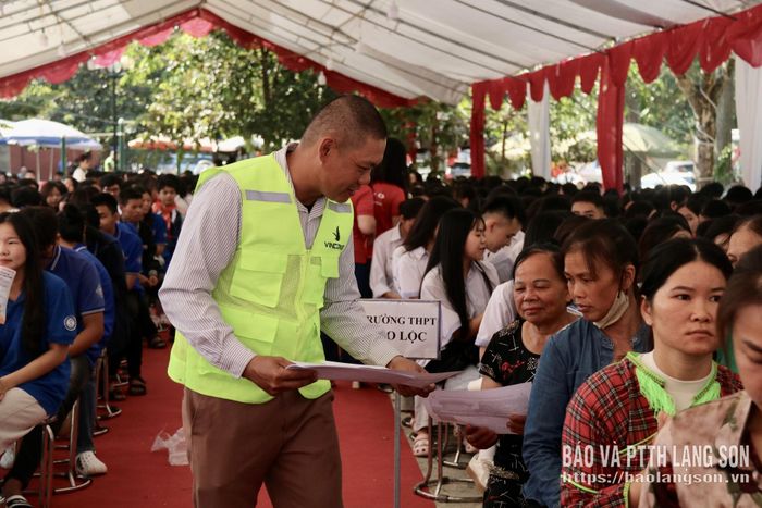Đại diện doanh nghiệp phát tờ rơi tư vấn việc làm cho người lao động