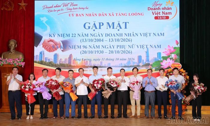 Lãnh đạo xã tặng hoa chúc mừng đại diện các doanh nghiệp nhân Ngày Doanh nhân Việt Nam.