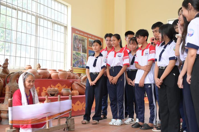 Thế hệ trẻ xem các nghệ nhân người Chăm dệt vải bên khung cửi