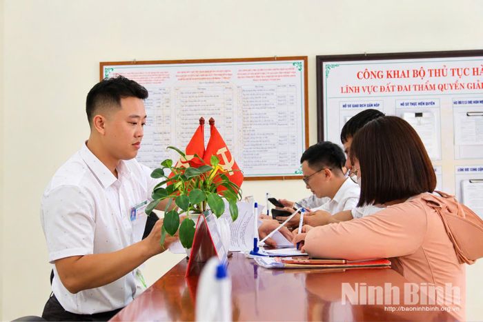 Cán bộ Chi nhánh Văn phòng Đăng ký đất đai Hải Hậu hướng dẫn người dân giải quyết thủ tục hồ sơ.