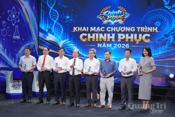 Ông Võ Nguyên Thủy, Giám đốc Báo và phát thanh, truyền hình Quảng Trị, Trưởng ban Tổ chức chương trình Chinh phục 2026 (đứng thứ 4 từ trái qua) trao cúp lưu niệm cho các thành viên Ban Tổ chức - Ảnh: L.T