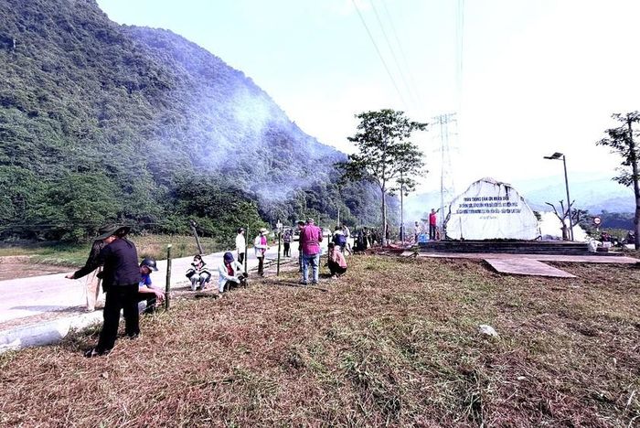 Các thầy, cô giáo và học sinh phát quang, vệ sinh môi trường khu vực "Phiến đá tri ân" người dân hiến đất mở đường ở Tân Lĩnh. Ảnh: Thu Hương