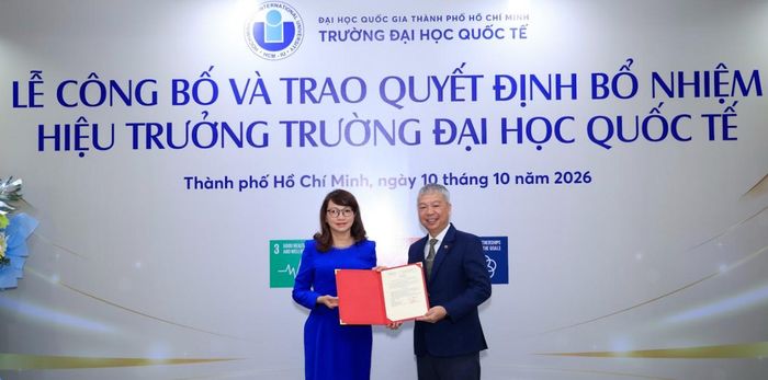 GS.TS. Nguyễn Thị Thanh Mai - Bí thư Đảng ủy, Giám đốc ĐHQG-HCM – trao Quyết định và tặng hoa chúc mừng Tiến sĩ Nguyễn Quốc Chính sáng 10/10/2026