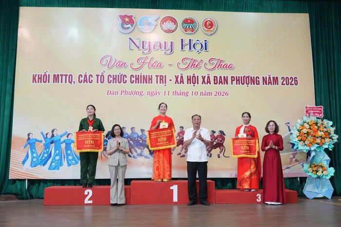 Bí thư Đảng ủy, Chủ tịch HĐND xã Đan Phượng Nguyễn Gia Hiển; Phó Bí thư Thường trực Đảng ủy xã Nguyễn Thị Hiền và Chủ tịch Ủy ban MTTQ Việt Nam xã Nguyễn Thị Thủy trao giải trình diễn dân vũ. Ảnh: Nga Nguyễn