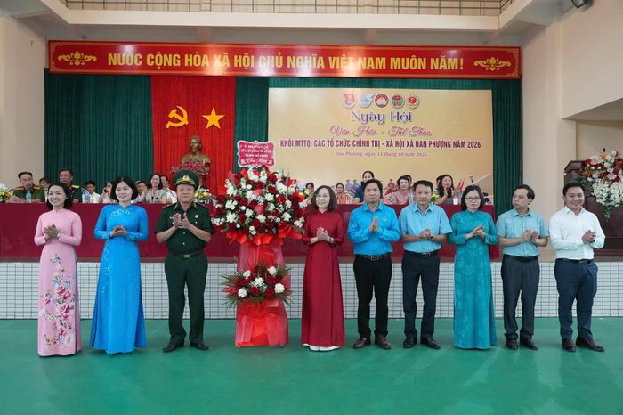 Thiếu tướng Lê Như Đức, Phó Chủ tịch Ủy ban Mặt trận Tổ quốc Việt Nam thành phố Hà Nội, Chủ tịch Hội Cựu chiến binh thành phố tặng hoa chúc mừng. Ảnh: Nga Nguyễn
