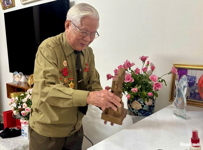 NSƯT Phùng Đệ bên kỷ vật gắn bó với Trung đoàn Thủ đô. Ảnh: Nguyệt Ánh