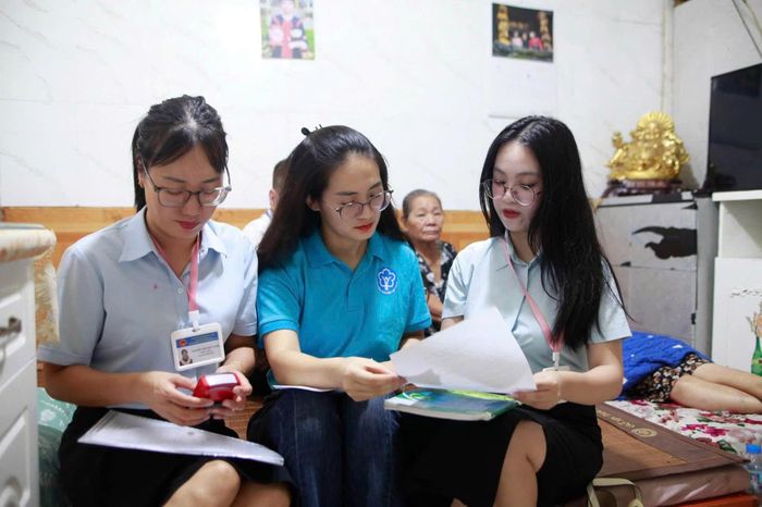 Cán bộ BHXH thành phố Hà Nội hỗ trợ người dân thực hiện ủy quyền hưởng lương hưu và trợ cấp BHXH. Ảnh: PV