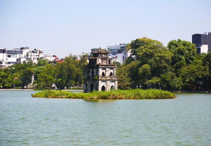 Giữa làn nước êm đềm cùng rặng cây xanh thắm, Tháp Rùa cổ kính như một điểm tựa bình yên của phố phường