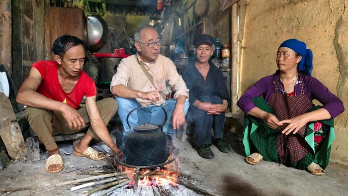 Ông Yasushi Ogura (giữa) trò chuyện với chủ nhà bằng tiếng Việt ngay bên bếp lửa về dự án mà ông đang ấp ủ để người dân hiểu. Ảnh: Huy Thông