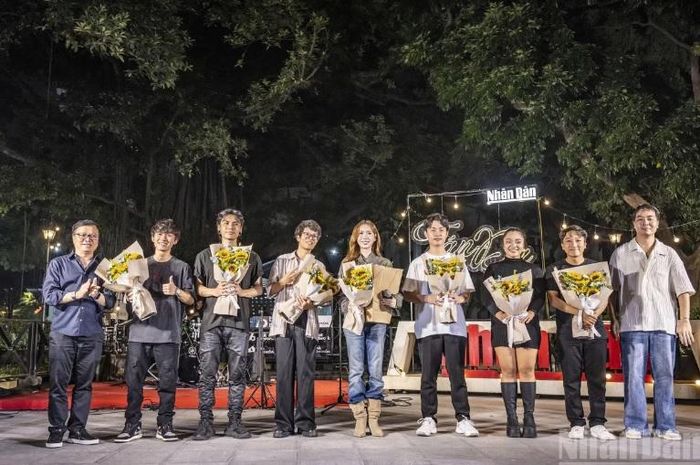 Nhà báo Lê Quốc Minh, Ủy viên Trung ương Đảng, Tổng Biên tập Báo Nhân Dân, Phó Trưởng Ban Tuyên giáo Trung ương, Chủ tịch Hội Nhà báo Việt Nam (ngoài cùng bên trái) tặng hoa cho các ca sĩ biểu diễn tại chương trình. Ảnh: BTC