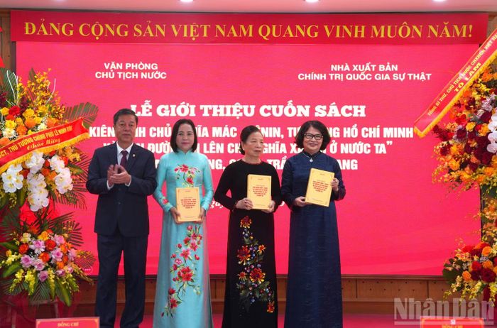 Đồng chí Vũ Trọng Lâm, Giám đốc-Tổng Biên tập Nhà xuất bản Chính trị quốc gia Sự thật trao cuốn sách tặng các đồng chí lãnh đạo, nguyên lãnh đạo Đảng, Nhà nước và đại diện gia đình nguyên Chủ tịch nước Trần Đại Quang. (Ảnh: HẢI ĐĂNG)