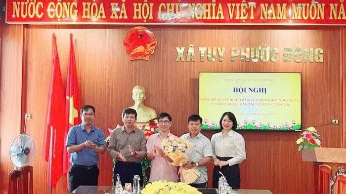 Giám đốc Ngân hàng chính sách xã hội Tuy Phước Nguyễn Hoàng Nhất Nam (người mặc áo hồng đứng giữa) dự lễ thành lập ban đại diện Hội đồng quản trị Ngân hàng chính sách xã hội xã Tuy Phước Đông.