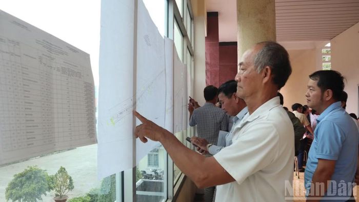 Người dân xã Bến Lức xem bản đồ quy hoạch Vành đai 4 và danh sách niêm yết nhận tiền bồi thường giải phóng mặt bằng. (Ảnh: THANH PHONG)