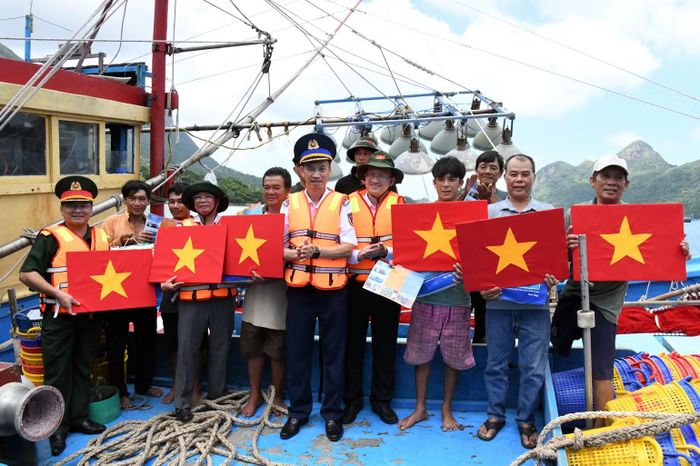 Thủ trưởng Bộ Tư lệnh Vùng Cảnh sát biển 3 tặng cờ Tổ quốc cho ngư dân. (Ảnh: Cảnh sát biển cung cấp)