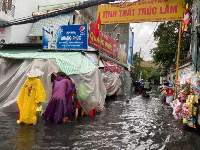 Nước ngập sâu ảnh hưởng việc mua bán của người dân trên đường Võ Thị Sáu.