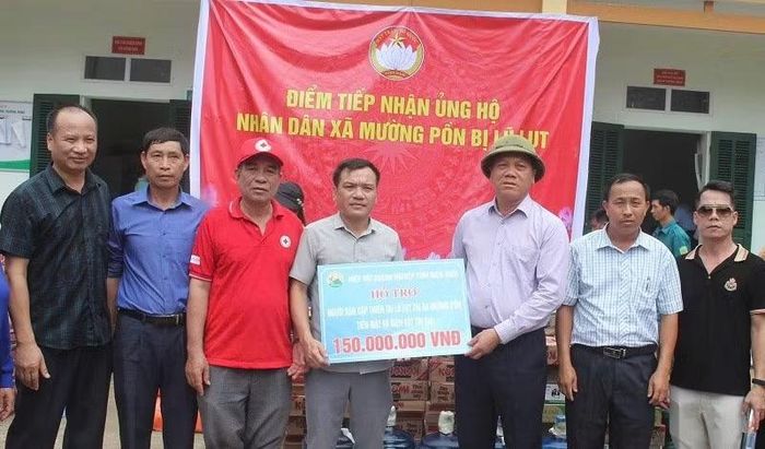 Ông Bùi Đức Giang, trao quà và tiền mặt hỗ trợ người dân bị thiệt hại lũ quét ở Mường Pồn. (Ảnh: LÊ LAN)