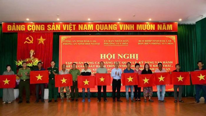 Đại diện các đơn vị và địa phương trao cờ Tổ quốc tặng ngư dân trong hội nghị ra mắt mô hình “Đồng hành cùng ngư dân Tuy Hòa chấp hành pháp luật, vươn khơi bám biển an toàn”. (Ảnh: NGỌC LÂN)