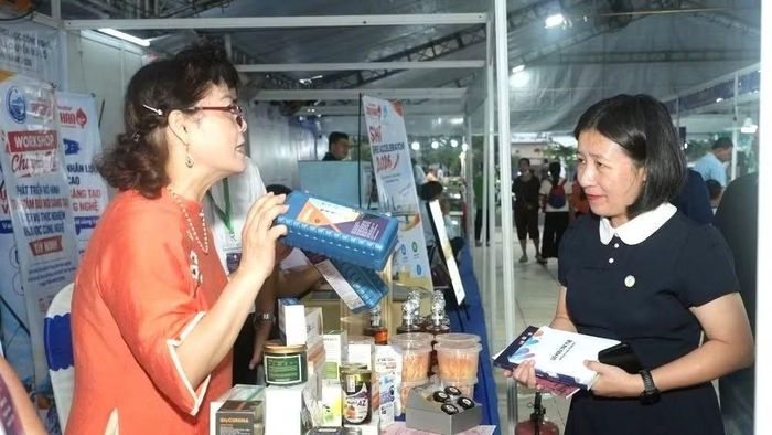 Bà Huỳnh Thị Hồng Nhung, Giám đốc Sở Khoa học và Công nghệ tỉnh Tây Ninh (bên phải ảnh), quan tâm đến các sản phẩm khoa học của các nữ trí thức Việt Nam. (Ảnh: BAN TỔ CHỨC)