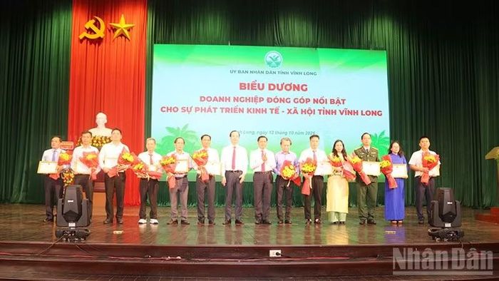 Đại diện các doanh nghiệp có đóng góp nổi bật cho phát triển kinh tế-xã hội tỉnh được Ủy ban nhân dân tỉnh Vĩnh Long biểu dương, khen thưởng. (Ảnh: MINH KHỞI)