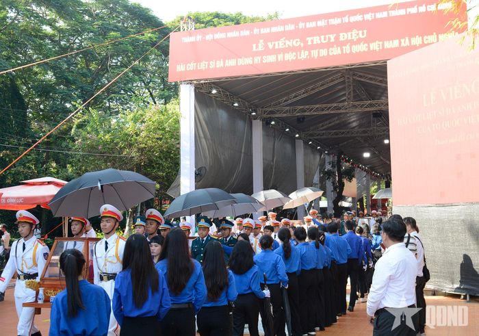 Đoàn viên, thanh niên thực hành che ô trong đội hình di chuyển hài cốt liệt sĩ. 