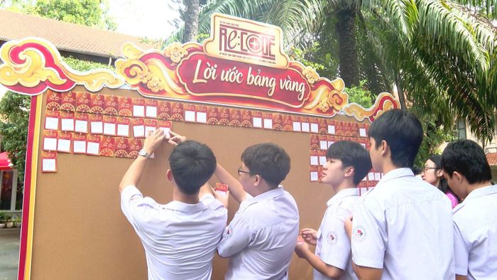 Học sinh Trường THPT Lê Quý Đôn viết ước mơ của mình dán lên "Bảng vàng lời ước" được trưng bày bên cạnh tượng nhà bác học Lê Quý Đôn đặt trong khuôn viên trường