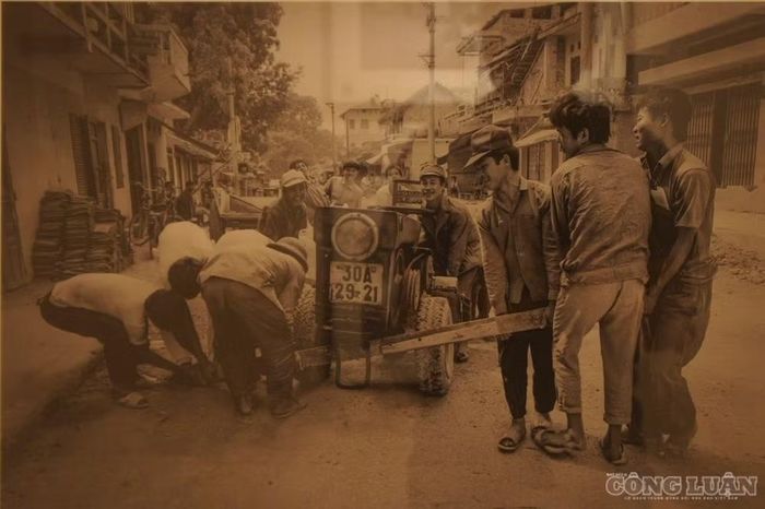 Bức ảnh "Working to repair the old tractor" (Những người đàn ông đang sửa chữa chiếc máy kéo cũ)