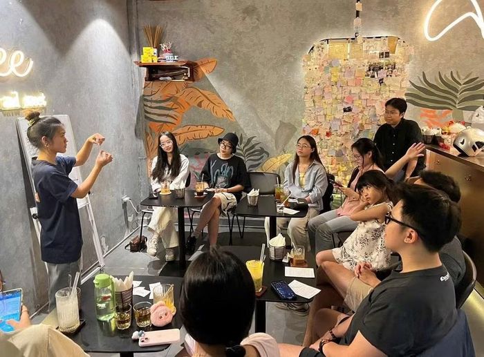 Nhân viên quán trực tiếp hướng dẫn khách hàng ngôn ngữ ký hiệu. Ảnh: Fanpage Flow-ee