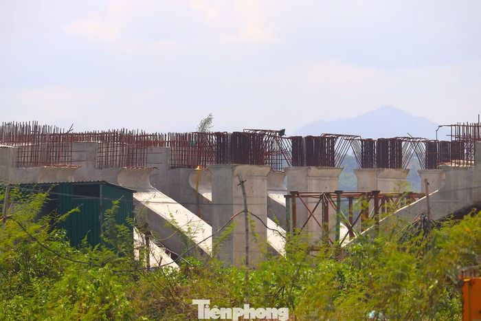 Do nhiều vị trí ngập nước, hoạt động thi công hiện tập trung vào các đoạn nền đường cao, từ đường Hoàng Hữu Thường đến đường Thuận Hóa (phường Phú Bài). Một số đoạn đã thảm bê tông nhựa mặt đường, trong khi gói thầu số 21 chưa thể triển khai đồng bộ. Trong ảnh là một cây cầu ở đầu tuyến tại phường Thanh Thủy thi công “nhỏ giọt”.