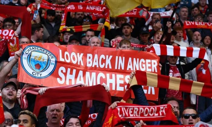  CĐV Liverpool giơ tấm biểu ngữ chế giễu Man City là đội bóng "lừa đảo". 