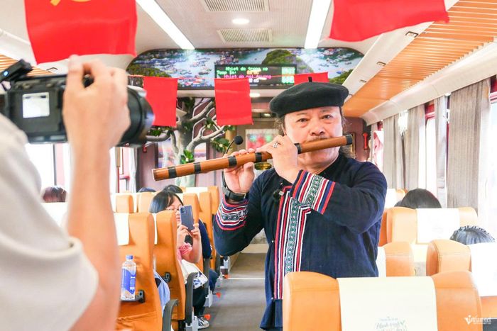 Nghệ nhân Thanh Lịch tới từng toa trình diễn sáo Mông. Du khách thích thú thưởng thức âm hưởng núi rừng