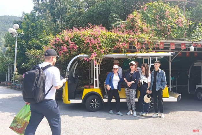 Đoàn du khách đến từ Đức chụp ảnh tại bến xe điện chùa Hương Tích dịp cuối tuần đầu tháng 10/2026.