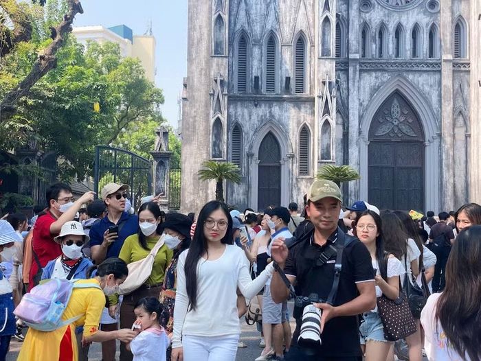 Không gian trước Nhà Thờ Lớn đông nghịt người đổ về, nhiều bạn trẻ kiên nhẫn chen chân tìm cho mình góc máy đẹp để lưu lại kỷ niệm bên nhà thờ cổ đẹp nhất Thủ đô. (Ảnh: Thanh Nga/Vietnam+)