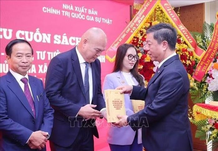 PGS.TS. Vũ Trọng Lâm, Giám đốc - Tổng Biên tập Nhà xuất bản Chính trị quốc gia Sự thật tặng sách cho các đại biểu. Ảnh: Văn Điệp/TTXVN