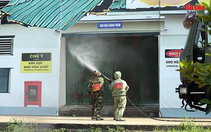 Nhân viên mặc trang phục bảo hộ phun nước xử lý sự cố tại khu vực kho hóa chất.