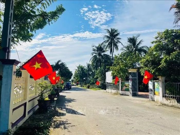 Những lá cờ được treo dọc các tuyến đường không chỉ làm đẹp cảnh quan mà còn gắn với việc vận động người dân giữ gìn vệ sinh, bảo đảm đường làng, ngõ xóm sạch sẽ.