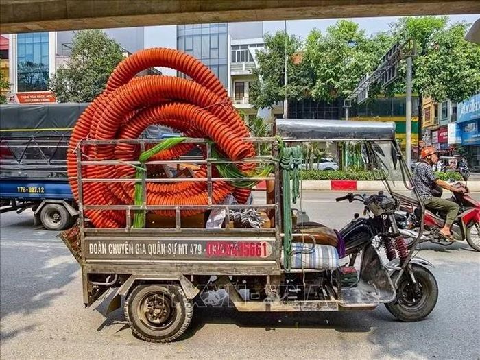 Xe ba bánh chở nhiều cuộn ống nhựa cỡ lớn lưu thông trên đường Quang Trung (Hà Nội), tiềm ẩn nguy cơ mất an toàn giao thông.