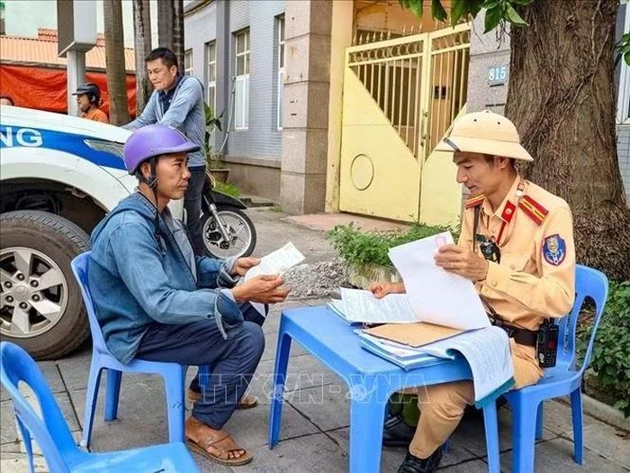 Cán bộ Đội Cảnh sát giao thông đường bộ số 10 kiểm tra giấy tờ, hoàn thiện hồ sơ xử lý trường hợp vi phạm trên đường Quang Trung, Thành phố Hà Nội.