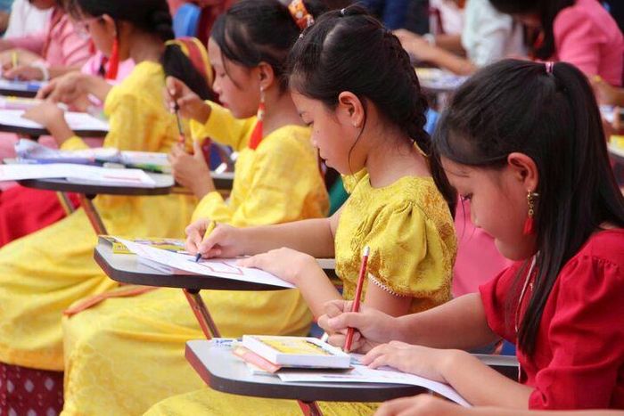 Các em thiếu nhi tham gia Hội thi viết chữ Chăm với chủ đề “Sáng nét chữ - Giữ hồn Chăm”. Ảnh: Mai Đông - Thanh Sơn.