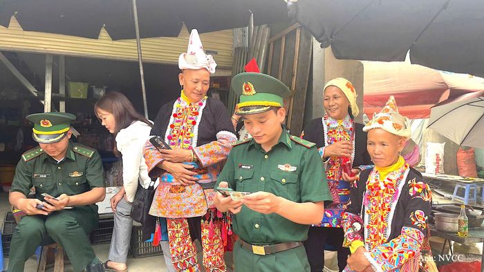 Thiếu tá Nguyễn Duy Khánh cùng tổ công tác hướng dẫn bà con bản Đồng Tiến, xã Sì Lở Lầu cài đặt ứng dụng định danh điện tử trên thiết bị di động.