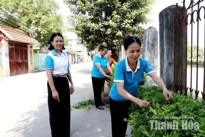 Hội viên phụ nữ xã Hoạt Giang chăm sóc tuyến đường hàng rào xanh, làm đẹp cảnh quan môi trường.