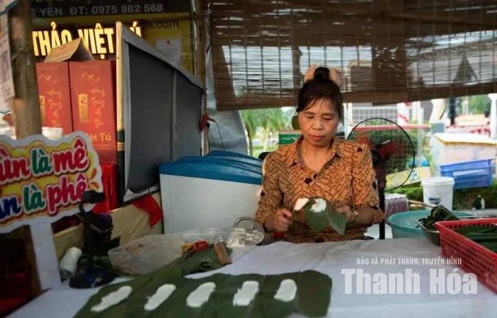 Đôi tay thoăn thoắt dàn đều từng muỗng bột tẻ mềm mướt lên phiến lá dong.
