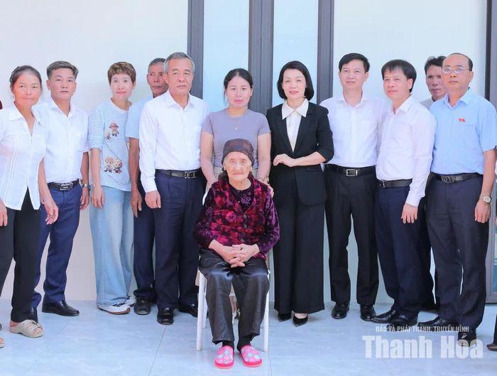 Bí thư Tỉnh ủy, Trưởng Đoàn ĐBQH tỉnh Lê Đức Thái chụp ảnh lưu niệm với bà Đỗ Thị Mơ cùng gia đình và lãnh đạo xã Lương Sơn.